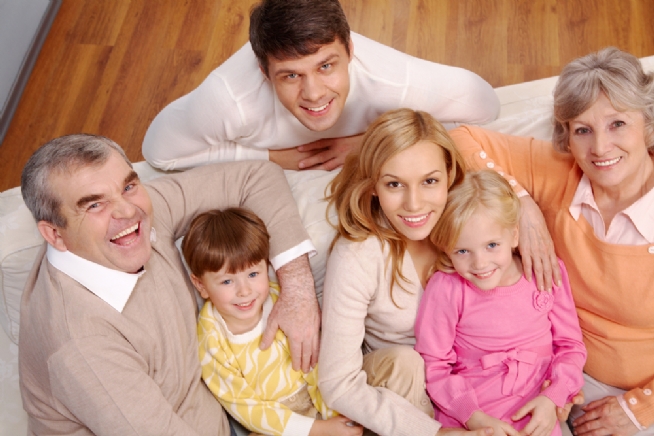 Portrait of senior and young couples and children looking at camera at home